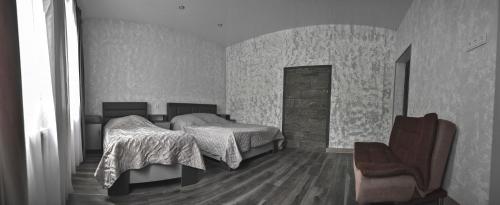 a bedroom with two beds and a chair at Welcome house in Dilijan
