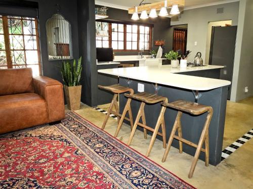 a kitchen with a counter and a bar with stools at 41 South in Mtunzini