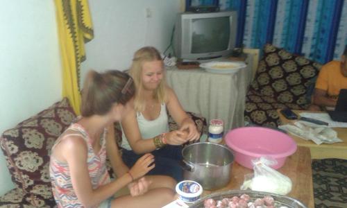 two girls sitting on a couch in front of a table at White And Blue in Essaouira