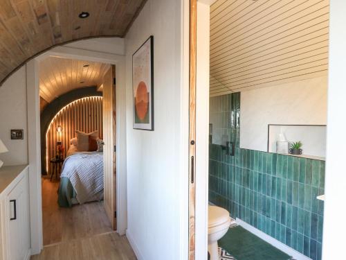 een badkamer met een toilet en een bed in een kamer bij Tan y Wawr- Onnen in Welshpool