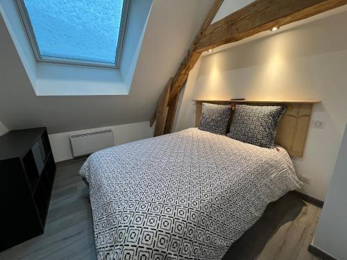 a bedroom with a bed and a window at Gîte Au Creux Du Moulin in Bussang