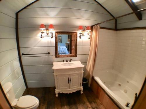 ein Badezimmer mit einem Waschbecken, einem WC und einer Badewanne in der Unterkunft Tiny Home Cottage Near the Smokies #7 Tilly in Sevierville