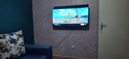 a flat screen tv hanging on a wall at Lakeside apartment in Kisumu