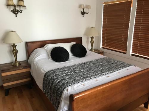 a bedroom with a bed with two black pillows on it at Le gîte du Lac à la Tortue in Herouxville