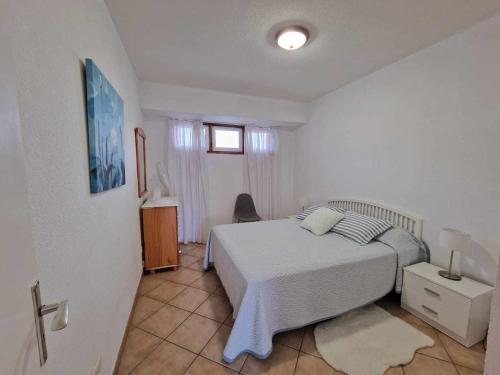 - une chambre avec un lit blanc et une fenêtre dans l'établissement MarketHome Playa la Arena I, à Santiago del Teide