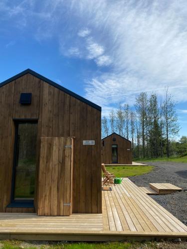 塞爾福斯的住宿－Bjarmaland Cottages，一座带木甲板的小型木制建筑
