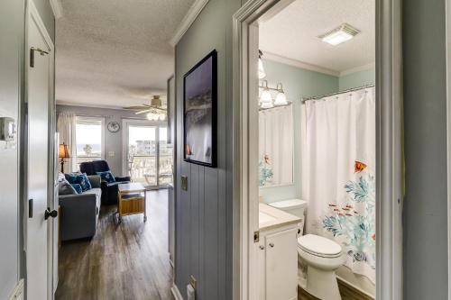 a bathroom with a toilet and a living room at 309A Sea Cabin in Isle of Palms