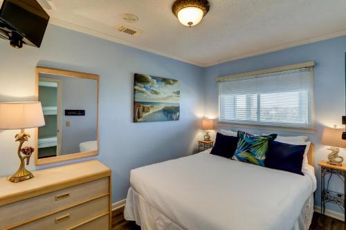a bedroom with a bed and a dresser and a mirror at 309A Sea Cabin in Isle of Palms