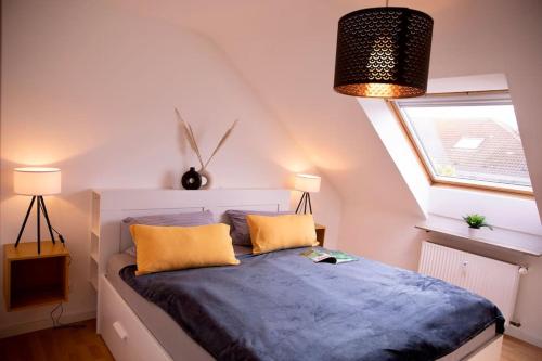 a bedroom with a bed with yellow pillows and a window at Stilvolles Apartment - Messe Rü Innenstadt in Essen