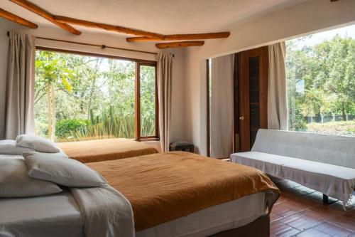um quarto com 2 camas e uma grande janela em La Leyenda Apartamentos em Villa de Leyva