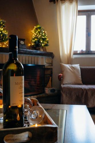 a bottle of wine sitting on a table in a living room at Παλαιό Λιθάρι in Ano Trikala