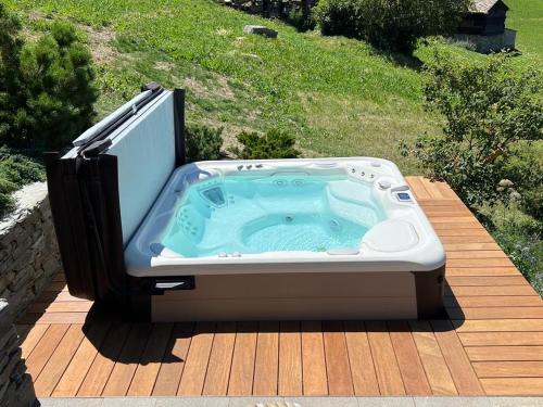 a hot tub sitting on top of a wooden deck at Sera Lodge in Grächen