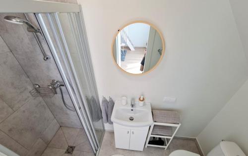 a bathroom with a sink and a shower and a mirror at Ladies Group apartments Palanga Vaivorykštės apartamentai 9c7 in Palanga