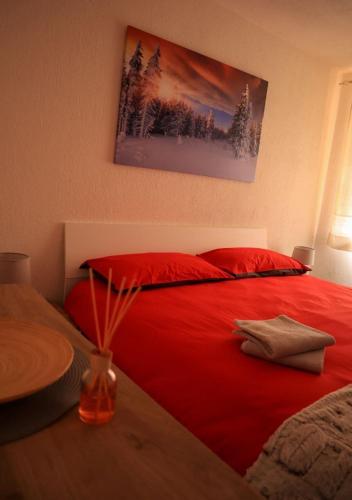 a bedroom with a red bed with red pillows at Maison Chez Les Roset in Arvier