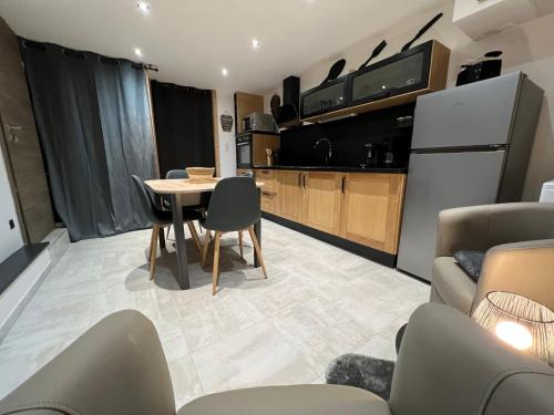 a kitchen and living room with a table and chairs at Gîte Au Creux Du Moulin in Bussang