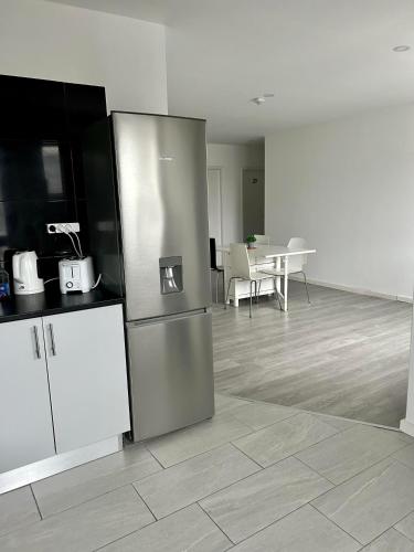 a kitchen with a stainless steel refrigerator and a table at Moreira Family in Porto