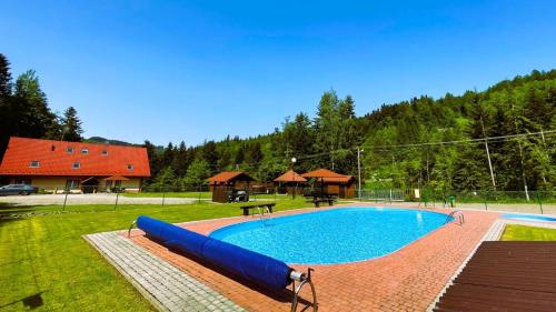 a large swimming pool in a yard with a house at Willa Arga in Piwniczna-Zdrój