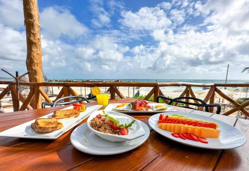 einen Tisch mit Teller mit Speisen auf einem Tisch am Strand in der Unterkunft Alito Tulum Hotel in Tulum