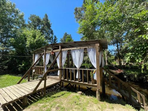 uma ponte de madeira com cortinas brancas em Mostrotel - Tu Hotel en el Delta em Tigre