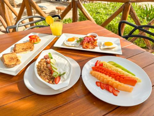 ein Tisch mit drei Tellern Frühstücksprodukt drauf in der Unterkunft Alito Tulum Hotel in Tulum