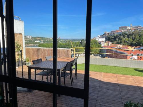 a view of a table and chairs from a window at Penthouse Terraço de Coimbra in Coimbra