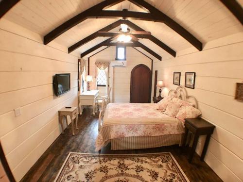 Tiny Home Cottage Near the Smokies #8 Helga في سيفيرفيل: غرفة نوم بسرير وتلفزيون في غرفة