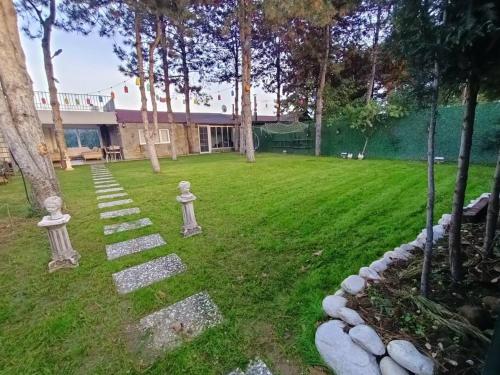 a garden with stone statues in the grass at Uludağ manzaralı kış bahçesi in Panayır