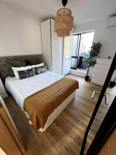 a bedroom with a large bed and a large window at Penthouse Terraço de Coimbra in Coimbra