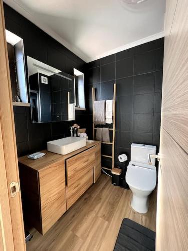 a bathroom with a white toilet and a sink at Penthouse Terraço de Coimbra in Coimbra