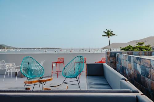 eine Gruppe von Stühlen und Tischen auf einem Gebäude in der Unterkunft Sable Bleu Boutique Hotel in Le Marin