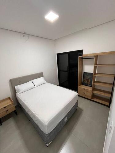 um quarto branco com uma cama e um armário em Casa com piscina completa no ABC em São Bernardo do Campo