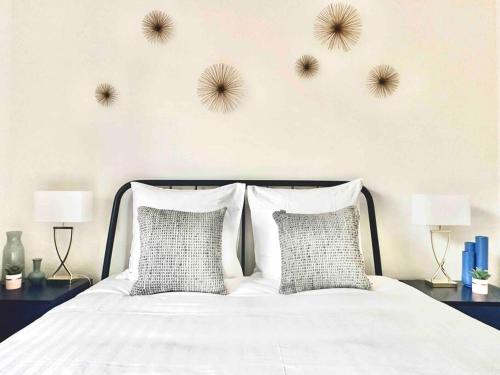 een slaapkamer met een wit bed met 2 kussens bij Superbe 8 couchages 200m de la mer - terrasse/clim in Saint-Raphaël