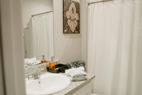 La salle de bains est pourvue d'un lavabo et d'un miroir. dans l'établissement Super Clean Fast Wifi Comfortable Beds, à Lake Charles