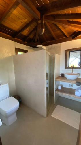 a bathroom with a toilet and a sink at Pousada Flor Do Mar in Caraíva