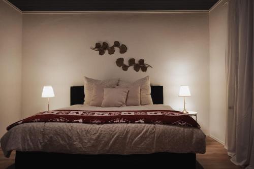 a bedroom with a large bed with two lamps at Charmantes & offenes Apartment in Ramstein-Miesenbach