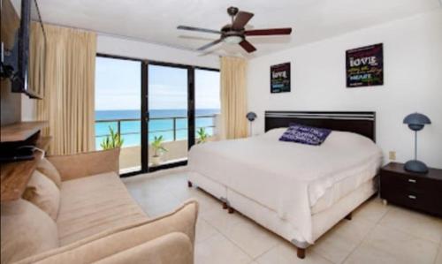 a bedroom with a bed and a balcony with the ocean at Perfect vacation getaway,Ocean View,Wifi, Beach in Cancún