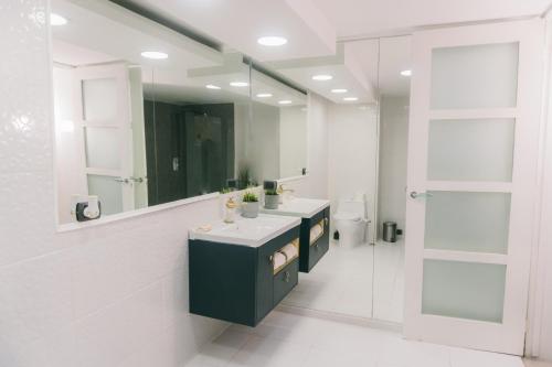 ein Badezimmer mit zwei Waschbecken, einem Spiegel und einem WC in der Unterkunft Oceanfront 3 Bedrooms With Pool in Santo Domingo