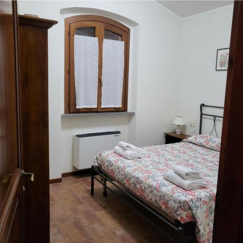 1 dormitorio con 1 cama con toallas en Casalta Case Vacanze, en Gubbio