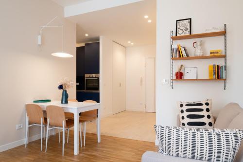 a dining room and living room with a white table and chairs at Realkasa Gallery Blue Suite in Bologna