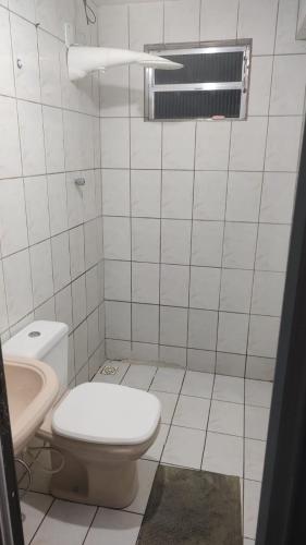 een witte badkamer met een toilet en een wastafel bij Estrela do norte in Serra