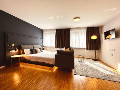 a bedroom with a bed and a couch in it at Stadthaus Neckarsulm serviced apartments - Stadthaus Schrade in Neckarsulm
