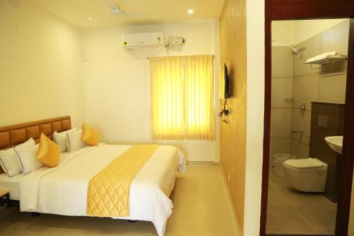 a hotel room with a bed and a bathroom at THE RIVIERA in Theni