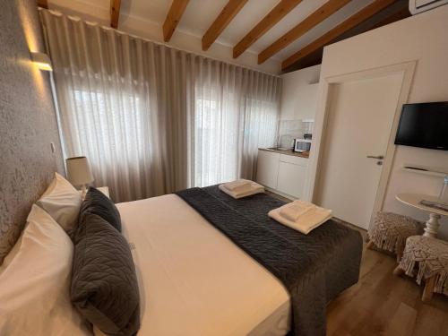 a bedroom with a bed with two towels on it at Douro Pateo House in Vila Nova de Gaia