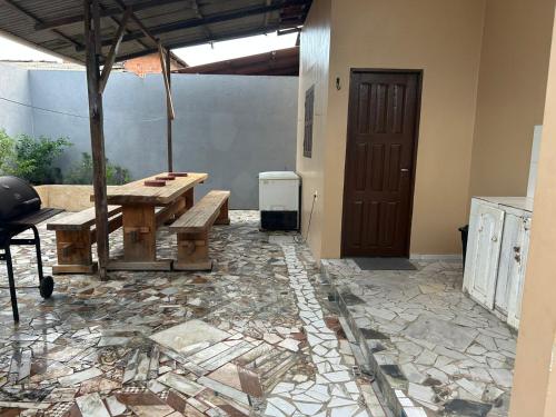 a patio with a wooden table and a wooden door at L & C - Casa por Temporada in Macapá