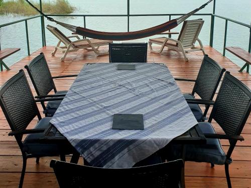 a table with chairs and a hammock on a deck at Cabana's on Gatun Lake in Arenosa in Arenosa