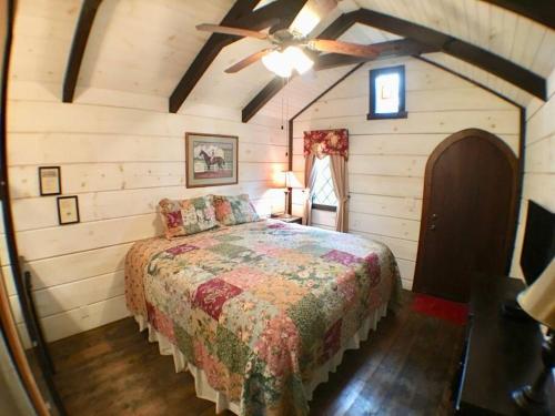 a bedroom with a bed and a ceiling fan at Tiny Home Cottage Near the Smokies #9 Frieda in Sevierville