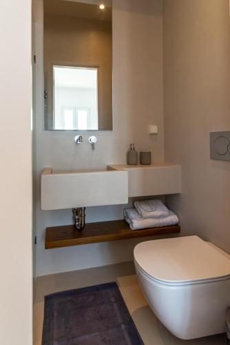 a bathroom with a white sink and a toilet at La Chapelle Ouest in Agios Romanos