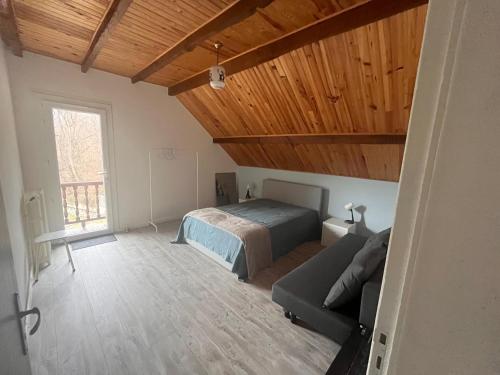 een slaapkamer met een bed en een bank bij Chalet d’Ax Pyrénées in Ax-les-Thermes