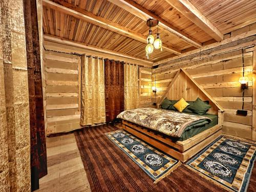 a bedroom with a bed in a log cabin at RAFA Shangarh in Sainj