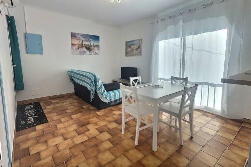 un salon avec une table et des chaises blanches dans l'établissement Gasc, à Valras-Plage